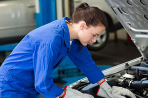 Mechanic inspecting car engine Female mechanic inspecting car engine