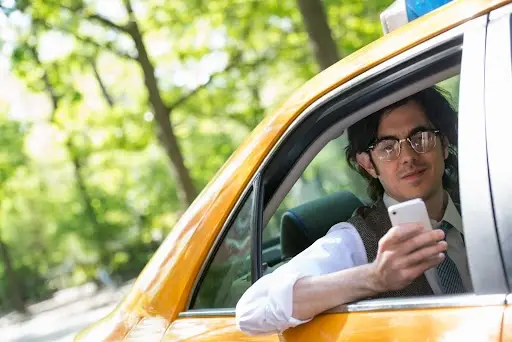 young man in back seat of yellow cab